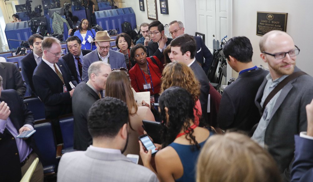 Reporters line up in hopes of attending a briefing in press secretary Sean Spicer's office at the White House in Washington on Friday. The White House held an off-camera briefing in Spicer's office, where they selected who could attend.