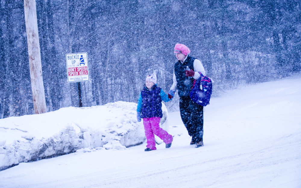 Flurries greet this parent and child Wednesday morning as they walk to Belgrade Middle School on Depot Road in Belgrade.