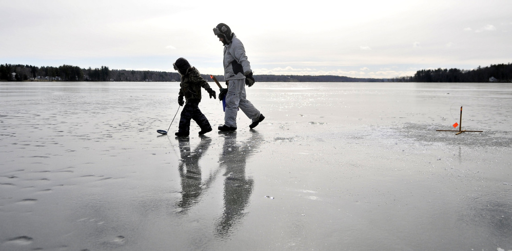 Kyle Willette, and his son Brody, 5, set the lines during a session of ice fishing on China lake near Causeway Road in China Friday. Willette noted the wind was not as bad as the past couple of days making Friday a perfect day on the ice.