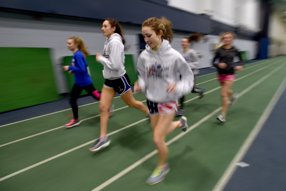 Messalonskee High School middle distance runner Avery Brennan, foreground, warms up with teammates for practice Wednesday at Colby College.