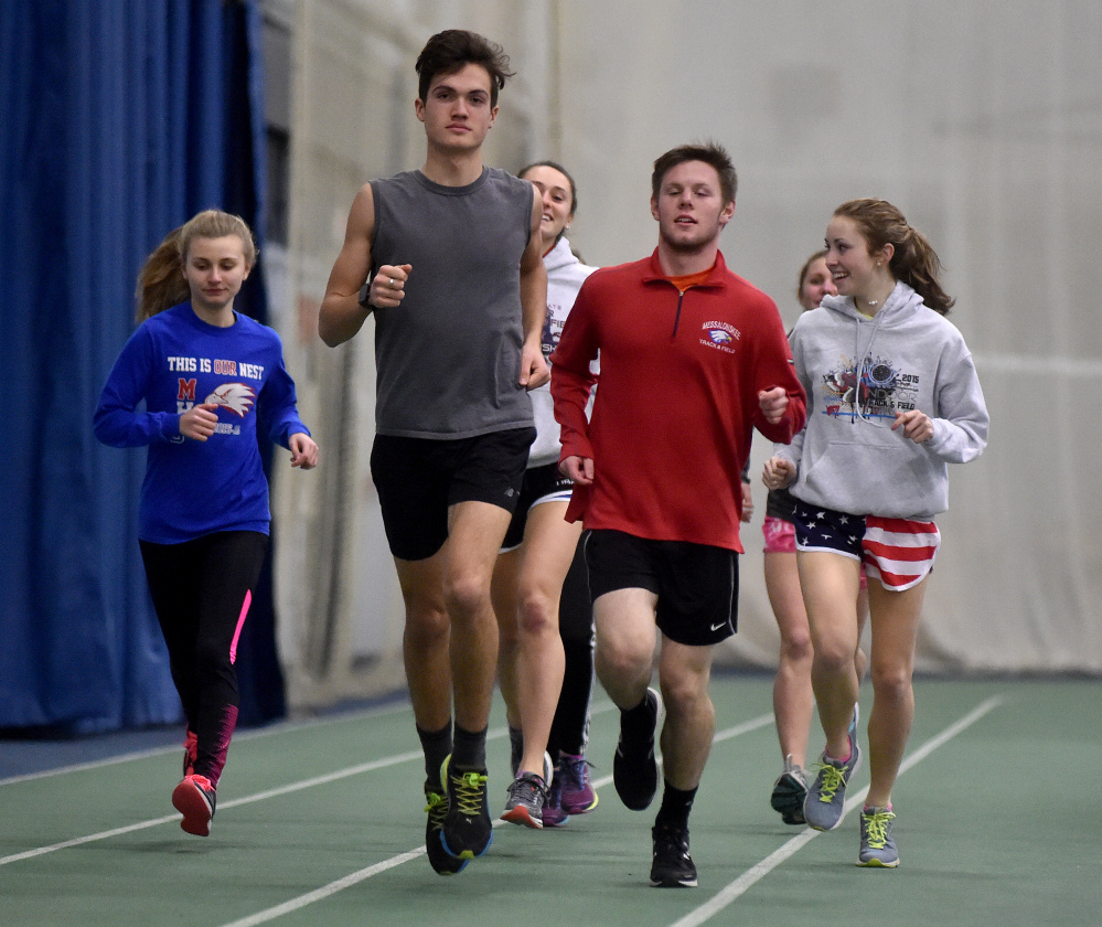 Messalonskee High School middle distance runners, Zach Hoyle, front center, Dan Turner, right center, and Avery Brennan, back right, warm up for practice at the Colby College field house earlier this week.
