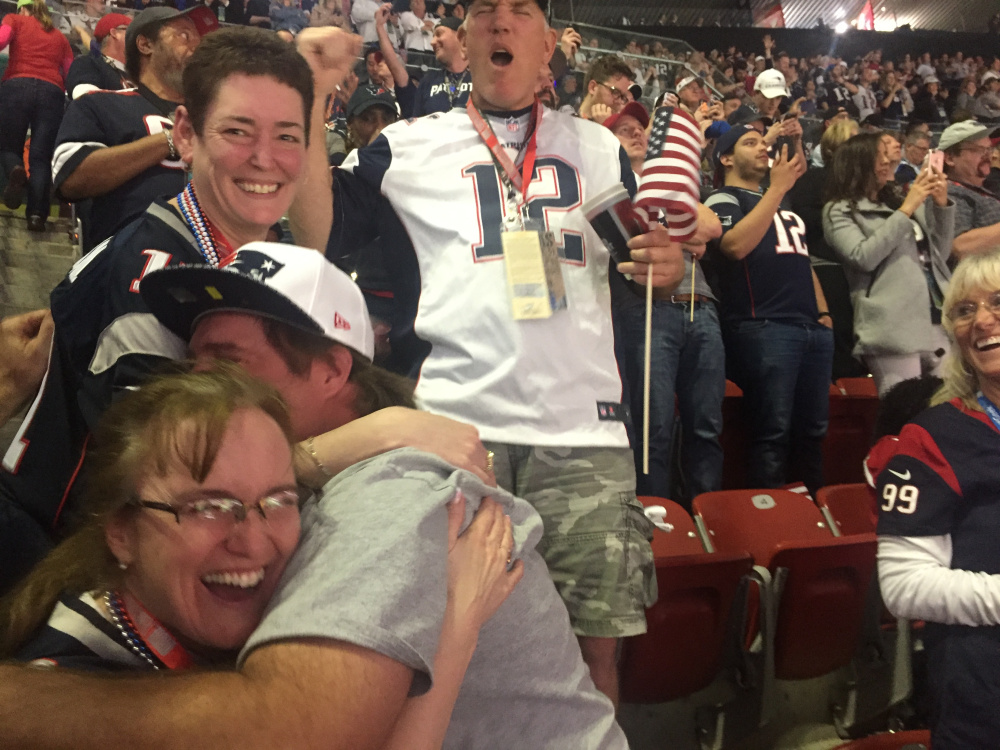 West Gardiner natives Cindy Smith, left, receives a hug from her brother Tim Greenleaf as fellow Patriot fans celebrate during Super Bowl 51 on Sunday night.