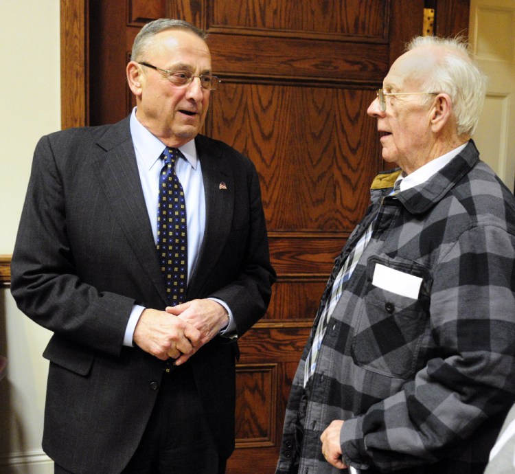 Gov. Paul LePage, left, chats with Richard Sukeforth at a Cabinet Room reception before the State of State address on Tuesday in the Maine State House in Augusta. Sukeforth and his wife lost their home when the town of Albion foreclosed and auctioned it off due to unpaid taxes. LePage mentioned wanting to change laws around that problem, citing the Sukeforths, during his speech.
