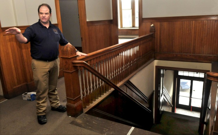 Travis Works, executive director of the Cornville Regional Charter School, points out the ornate woodwork, including the stairwell, in the former Variety Drug building in Skowhegan. The school is buying the property and will renovate the building into offices and rooms for classes.