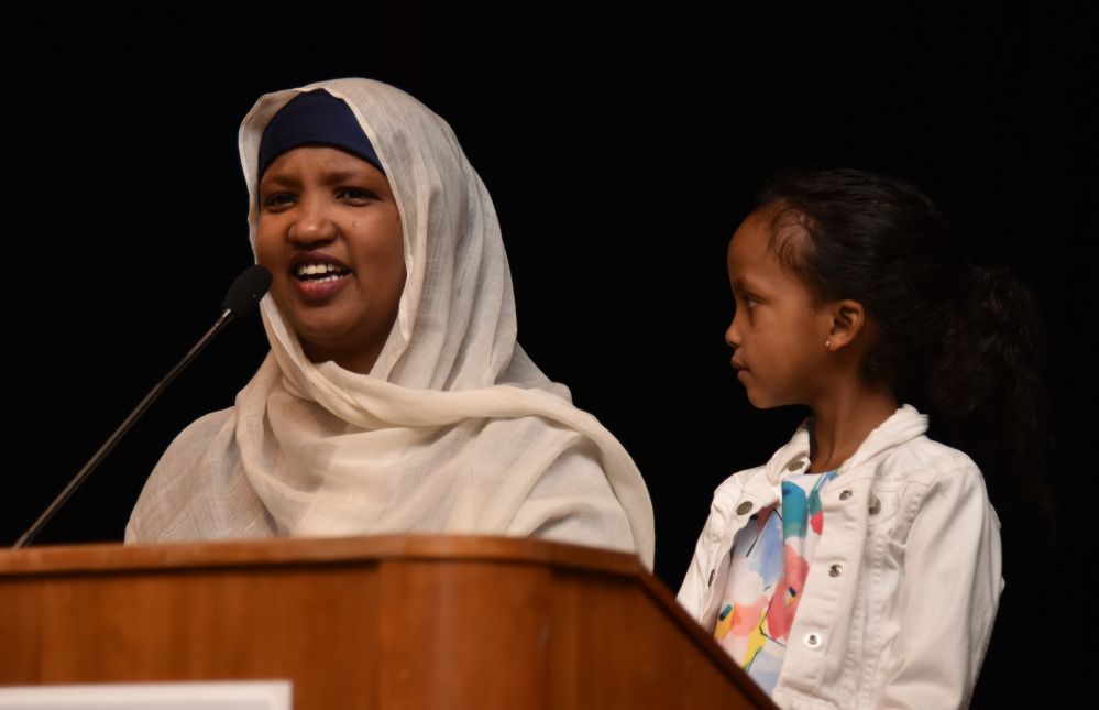 Fatuma Hussein, the founder and executive director of the Immigrant Resources Center of Maine, speaks on Wednesday night at a forum held at the University of Maine at Augusta in response to Ku Kllux Klan fliers placed around  Augusta and other locations in the state. Her daughter listens as Hussein talks about what it was like to move to Lewiston from Somalia.