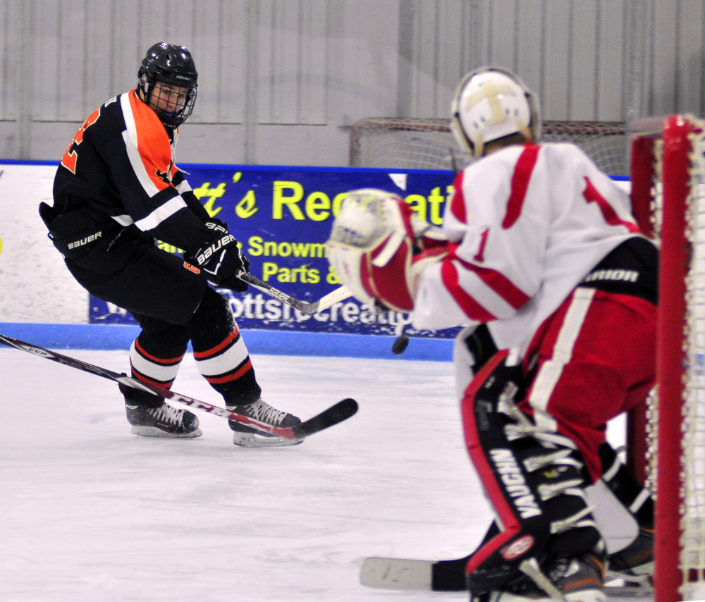 Gardiner's Joe Clark, top, shoots on Cony/Monmouth/Hall-Dale goalie Dalton Bowie during a game Friday at the Camden National Bank Ice Vault in Hallowell.