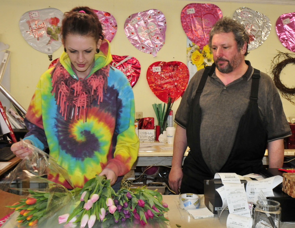 KMD Florist shop owner Dave Lagrange watches as employee Tavia Chamberlain makes a Valentine's Day bouquet at the Waterville business on Monday. Area florists are hoping for better conditions Tuesday to deliver flowers as it is one of the biggest days of the year for florists.