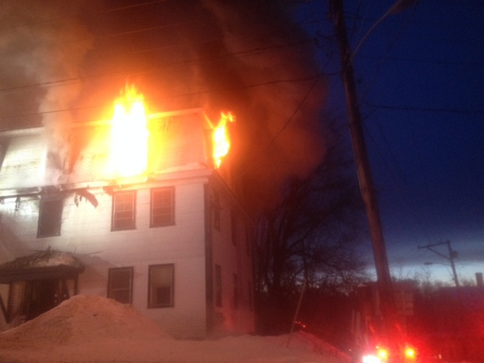 Firefighters work at the scene of a fire Tuesday evening at an apartment building at 11 Main St. in Skowhegan.
