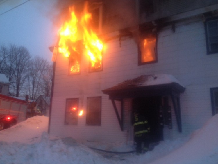 Flames spill out from the windows Tuesday evening of an apartment building at 11 Main St. in Skowhegan.