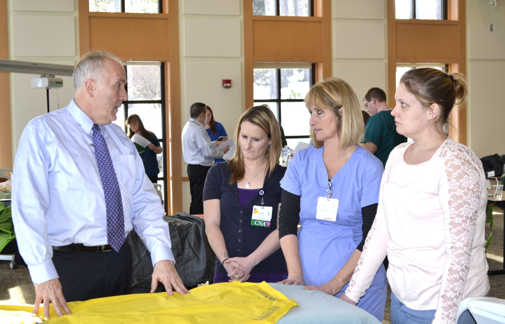Matt Center, left, demonstrated the proper use of a slip mat transfer device to prevent injuries to both patients and staff, as Brady Swett, Karla Dalessandro and Kayla Allen, all CNAs, look on. The demonstration was part of a "Safe Patient Handling Skills Fair" held Feb. 7-8 at Franklin Memorial Hospital in Farmington.