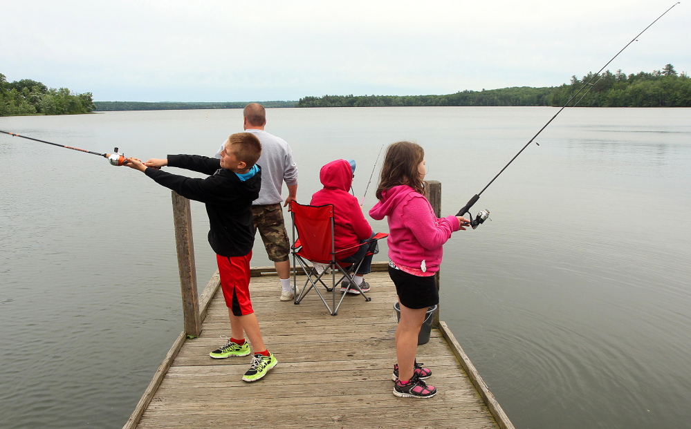 A Waterville family fishes in 2014 on China Lake in East Vassalboro. The Kennebec Water District, which owns the west basin shorefront there and draws its water supply from the lake for 30,000 customers, opposes legislation that would charge district users a $5 fee in order to help improve the lake's water quality.