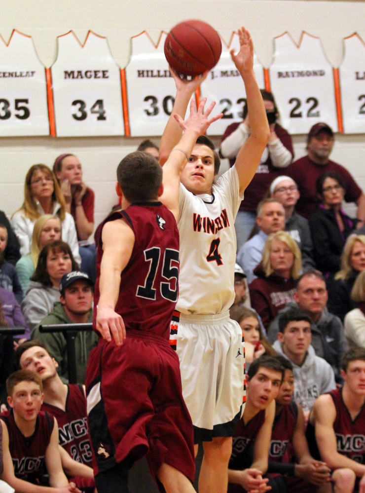 Winslow High School's Spencer Miranda shoots over Maine Central Institute's Josh Buker during the first half of a Class B North prelim game in Winslow on Thursday night.