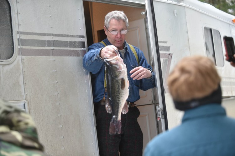Tom Bolon holds a 5-pound bass caught Saturday by Chris Lee during the Albion Lions Club-sponsored fifth annual Ice Fishing Derby on Lovejoy Pond in Albion.