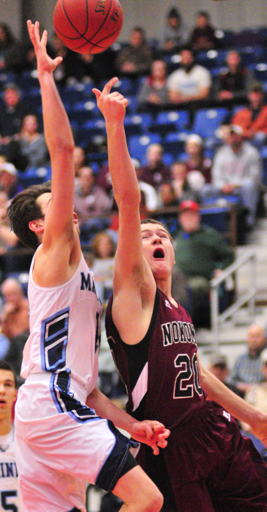 Staff photo by Joe Phelan
Oceanside senior guard Sam Atwood, left, tries to block a shot by Nokomis junior guard Zach Hartsgrove during a Class A North quarterfinal game Saturday at the Augusta Civic Center.