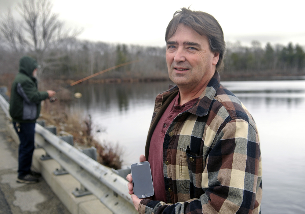 West Gardiner resident Ron Cote, shown in March 16, 2016, at Togus Pond in Augusta, has updated his fishing regulations smartphone app and now is offering it free.