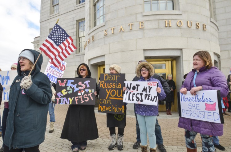 Kathleen Conrad, far left, of North Yarmouth, joins other protesters Monday at the State House in Augusta as part of a rally called Not My President's Day. The event was held to protest immigration restrictions and other policies of the Trump presidency, as well as the president himself.