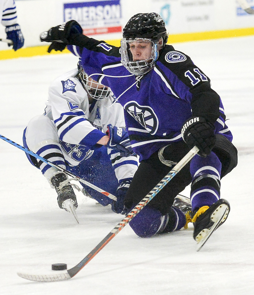 Waterville's Jackson Aldrich maintains control of the puck after being knocked to the ice by Lewiston's Brad McLellan Tuesday night in Lewiston.