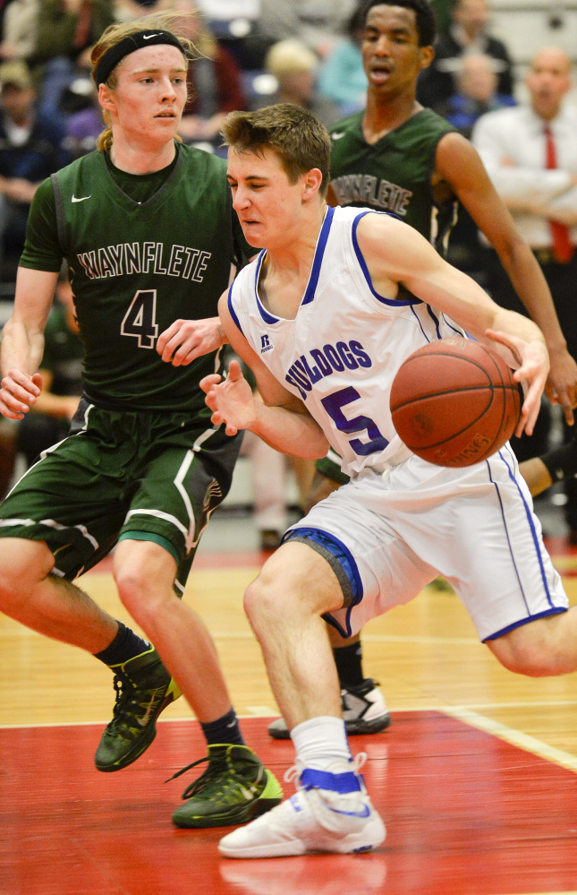 Madison's Sean Whalen races to get past Waynflete's Jack Meahl before executing a successful layup in the first half of a Class C South semifinal Thursday.