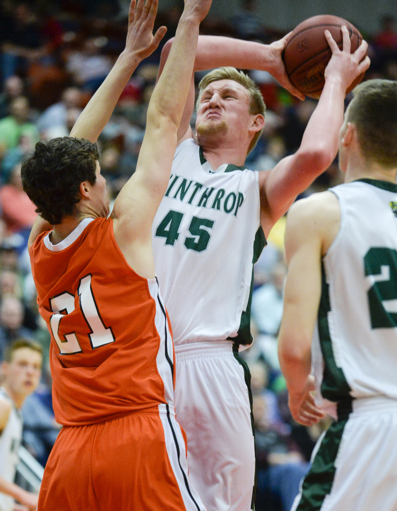North Yarmouth Academy's Jake Malcom (21) attempts to block Cameron Wood's shot in the first quarter of the Class C South semifinal after Wood nabbed a rebound under the basket Thursday at the Augusta Civic Center.