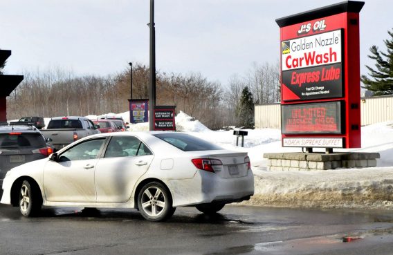 Vehicles are parked in a line on Kennedy Memorial Drive in Waterville to enter the J&S Oil car wash on Wednesday, a day after police warned motorists not to idle along the road while waiting in line for the car wash.