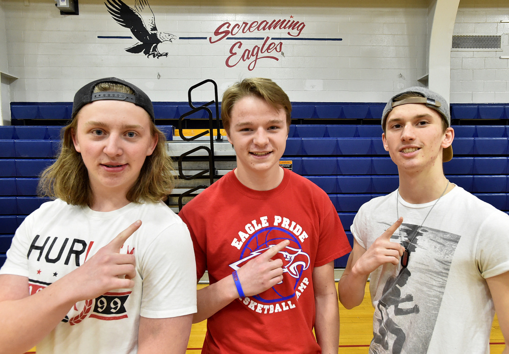 Messalonskee High School super fans Conor Ferguson, left, Colby Charette, center, and Tanner Burton, right, prepare for the state championship games for both girls and boys basketball teams Tuesday in Oakland.