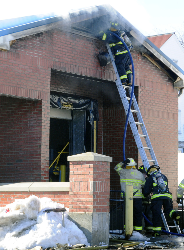 Firefighters work last week at the Winthrop post office, where federal officials have determined a fire probably was the result of a mechanical or electrical malfunction.