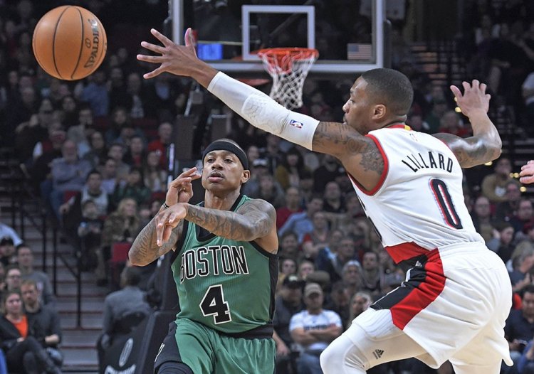 Boston Celtics guard Isaiah Thomas passes the ball past Trail Blazers guard Damian Lillard during the first half of Thursday night's game in Portland, Ore.