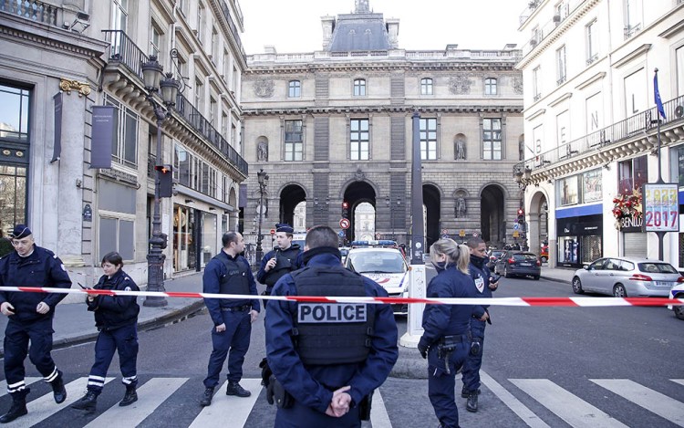 Police officers cordon off an area next to the Louvre in Paris Friday. Police say a soldier opened fire on an attacker  in an underground mall beneath the museum.
