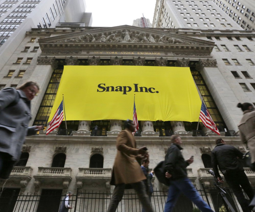 People pass by the New York Stock Exchange after the banner for the Snap Inc. IPO was raised on the building's facade Wednesday. Snap Inc. started trading Thursday.