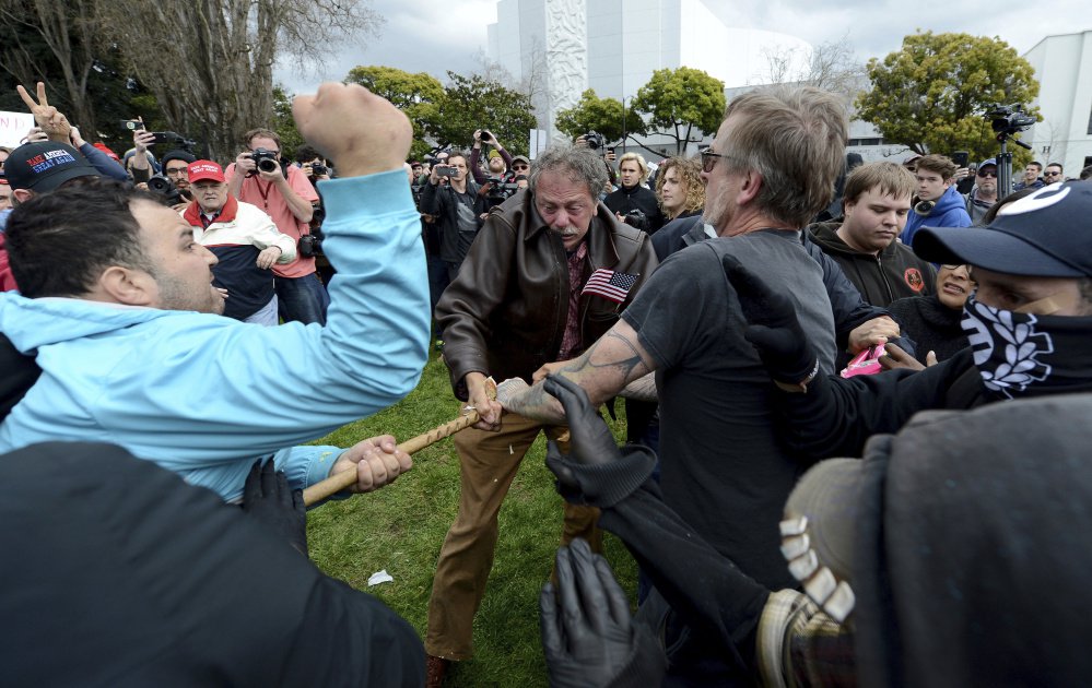 Anti-Trump protesters try to take a large piece of wood away from a Trump supporter at a rally for President Trump at Martin Luther King Jr. Civic Center Park in Berkeley, Calif., on Saturday. Police in riot gear arrested at least 10 people at the rally that attracted hundreds of pro-Trump supporters and opponents at the park.