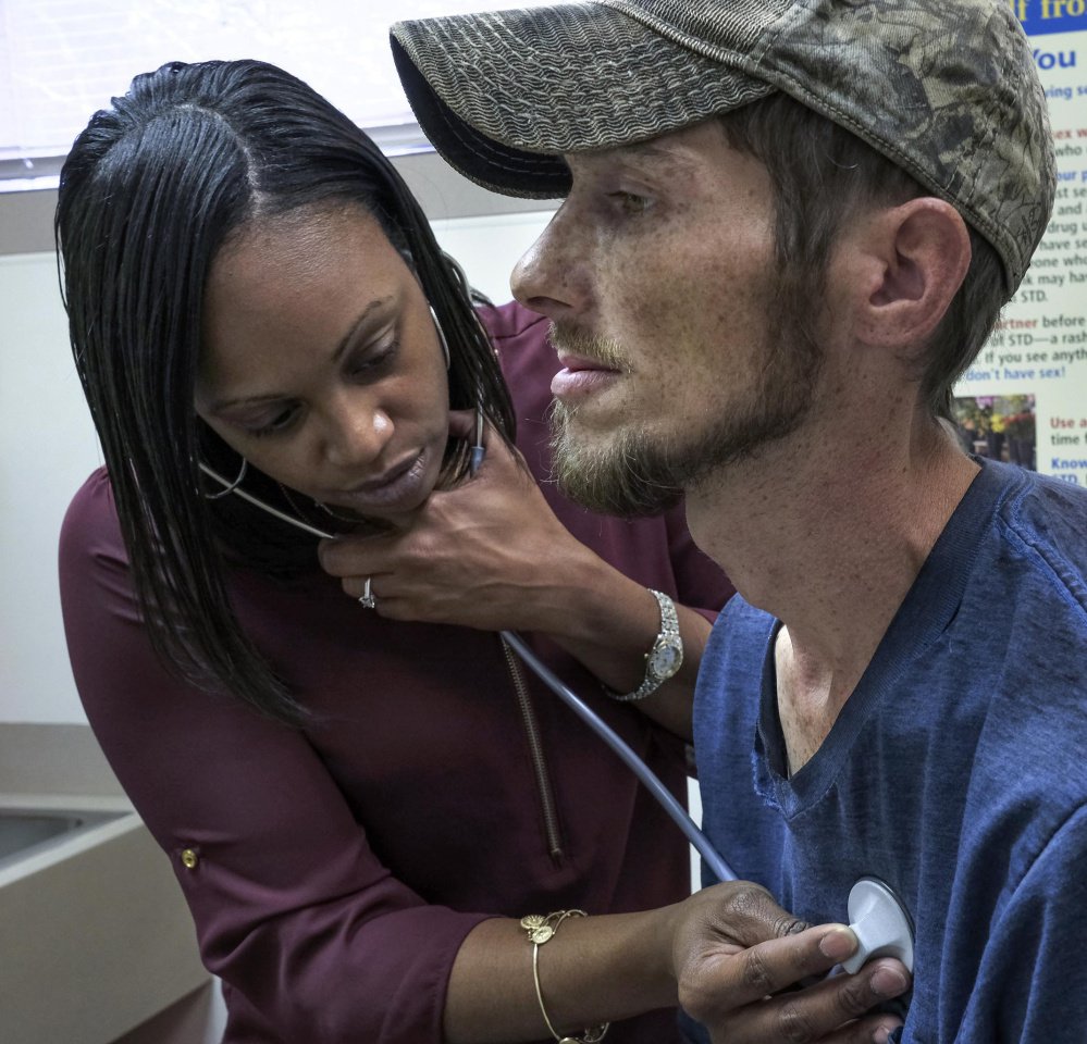 Nurse practitioner Keisha Saunders, who grew up in the community, examines Clarence Workman at the Tug River health clinic in Northfork, W.Va.