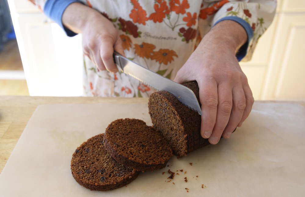 Press Herald food editor Peggy Grodinsky cuts brown bread for a meal to show that she belongs in Maine. Would Mainers consider the added currants too fancy?