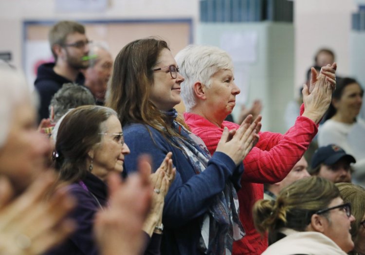 Audience members applaud the arrival of Rep. Chellie Pingree, D-Maine, at a health care town hall Sunday at King Middle School in Portland.