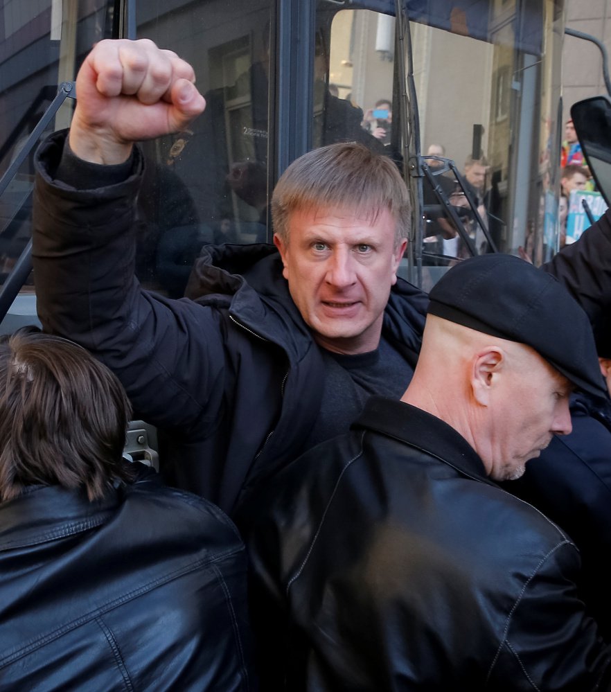 An opposition supporter gestures with a clenched fist as he blocks a police van transporting Alexei Navalny during the rally in Moscow.