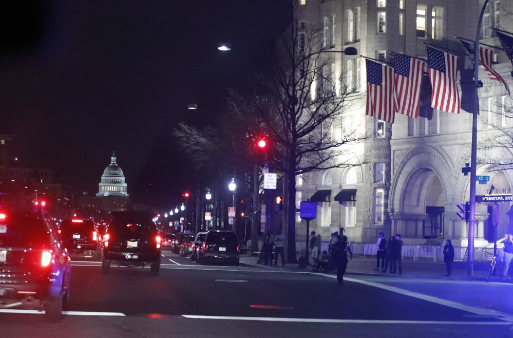 The president's motorcade arrives at the Trump International Hotel, right, where he had dinner Saturday night. The Trump Organization is scouting for a new hotel site in Washington.