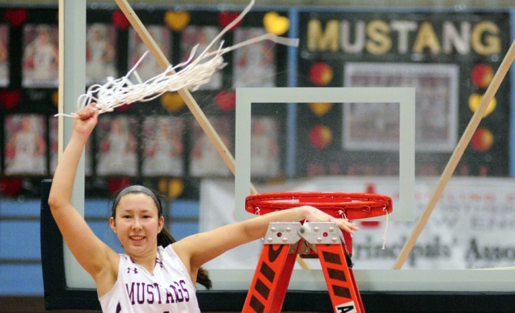 Monmouth's Tia Day swings a net in celebration after the Mustangs won the Class C South championship Saturday at the Augusta Civic Center. It was Monmouth's first regional title in Class C.