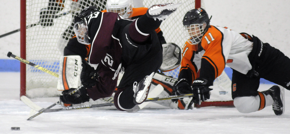 Gardiner's Sloan Berthiaume, right, stops Gorham's Adam Peterson during a Class B South quarterfinal game last season at the Camden National Bank Ice Vault in Hallowell.