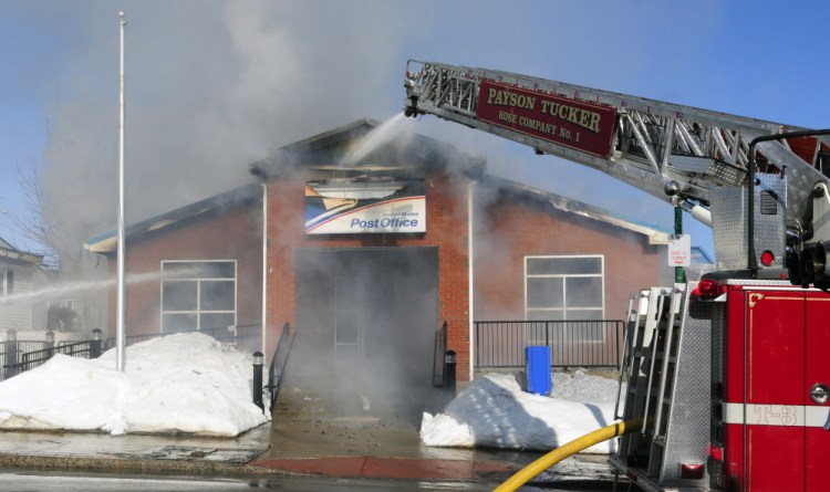 Firefighters work on Feb. 21 at the post office in Winthrop, which was destroyed by an accidental fire.
