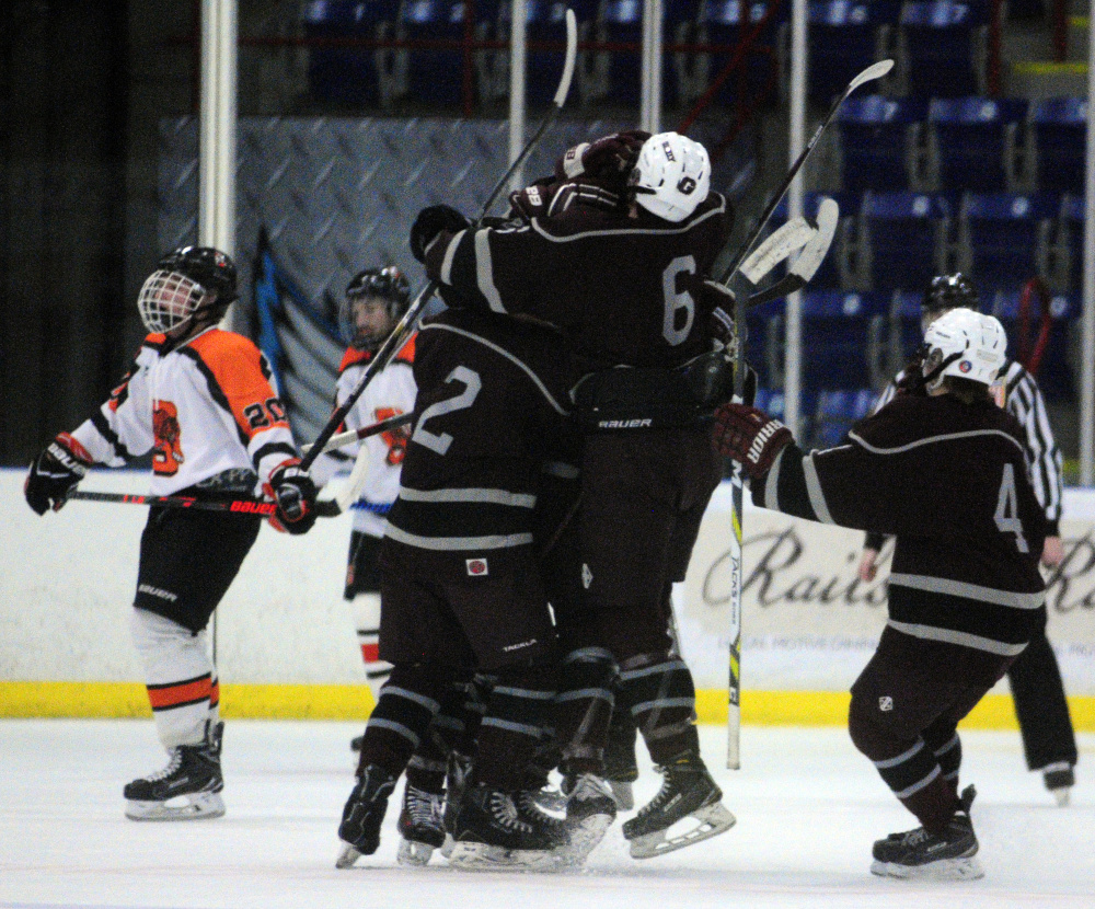 Members of the Greely hockey team mob freshman forward Jake MacDonald after his first period goal in a Class B South semifinal game against Gardiner on Friday night at the Androscoggin Bank Colisée in Lewiston.