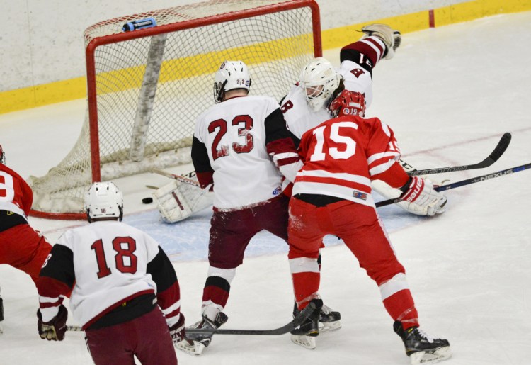 Cony's Cam Wilson, left, scores a goal past Bangor goalie Zach Alden in the first period of the Class A North semifinal Saturday in Lewiston. Bangor went on to win 2-1.