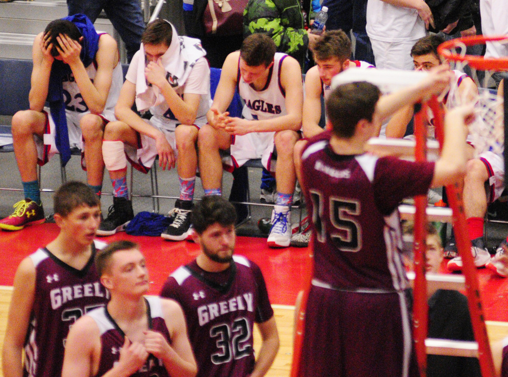 Messalonskee players look away as Greely's Andrew Miller cuts down the net after Rangers won the Class A state championship Saturday at the Augusta Civic Center.