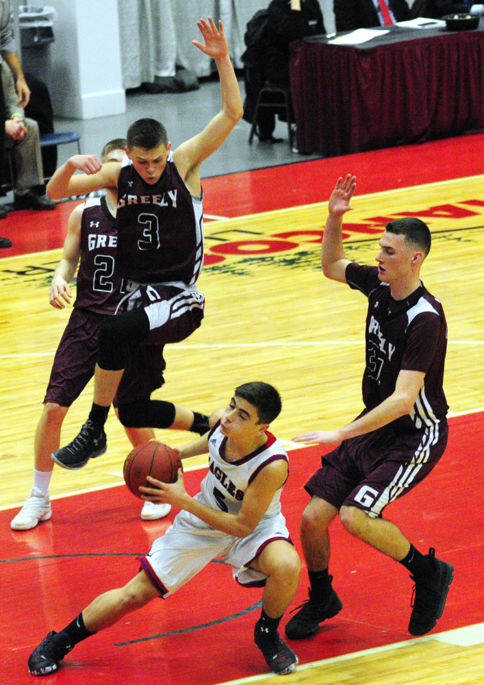 Messalonskee's Chase Warren gets double teamed by Greely's Jordan Bashaw, top left, and Matt McDevitt in the Class A state final Saturday at the Augusta Civic Center.