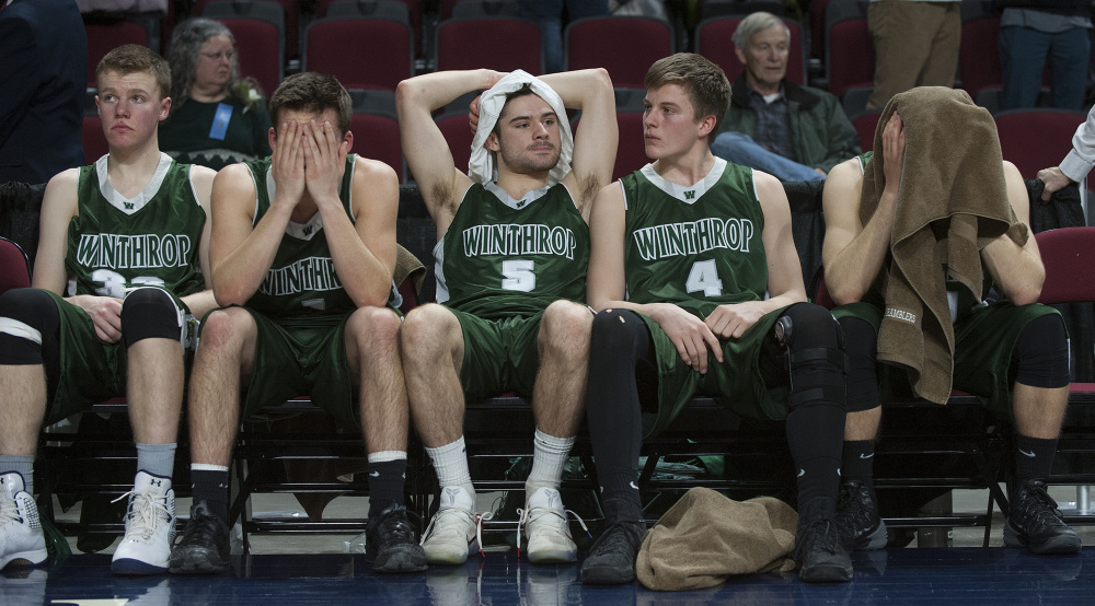 Members of the Winthrop boys basketball team react after George Stevens Academy won the Class C sate title Saturday at the Cross Insurance Center in Bangor.
