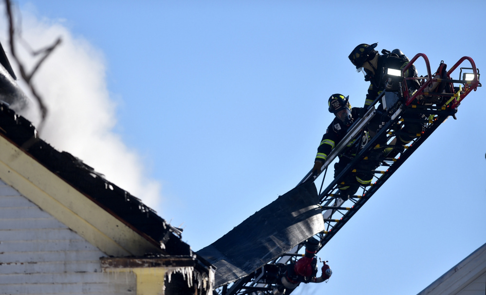 Firefighters from several towns battle a blaze Saturday afternoon on Main Street in Madison.