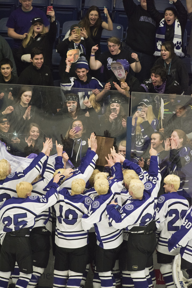 The Waterville hockey team celebrates after they won the Class B North championship with a 6-5 overtime victory over Old Town/Orono on Tuesday night in Orono.