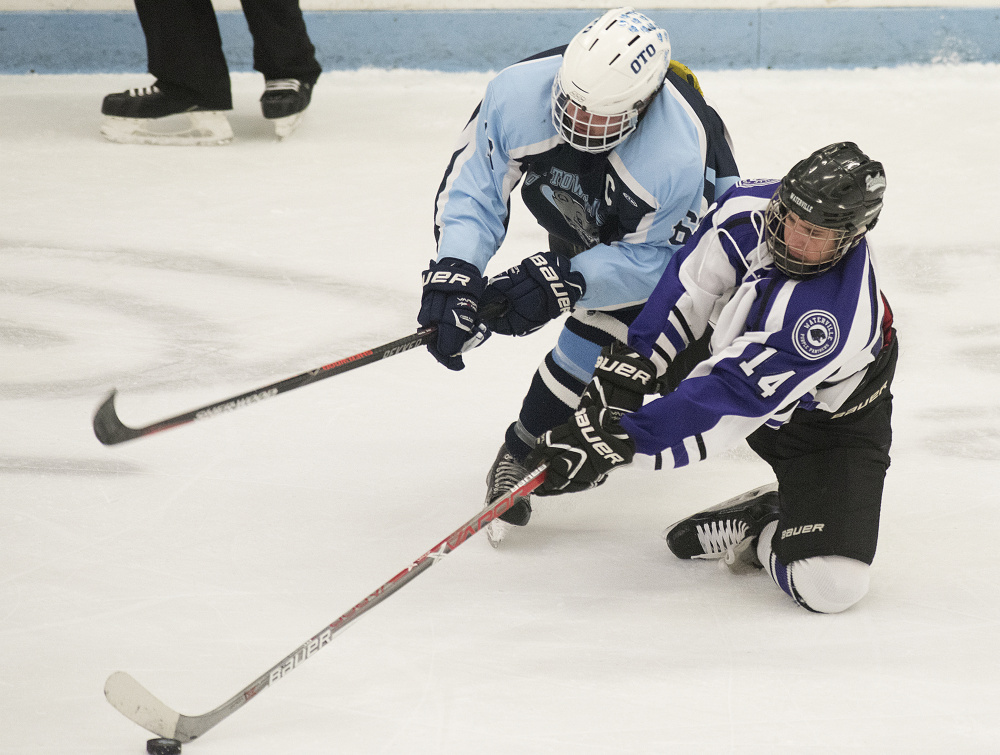 Old Town/Orono's Austin Sheehan and Waterville's Michael Bolduc battle for the puck during the Class B North regional championship Tuesday in Orono. The Purple Panthers play York at 1 p.m., today for the Class B state championship.