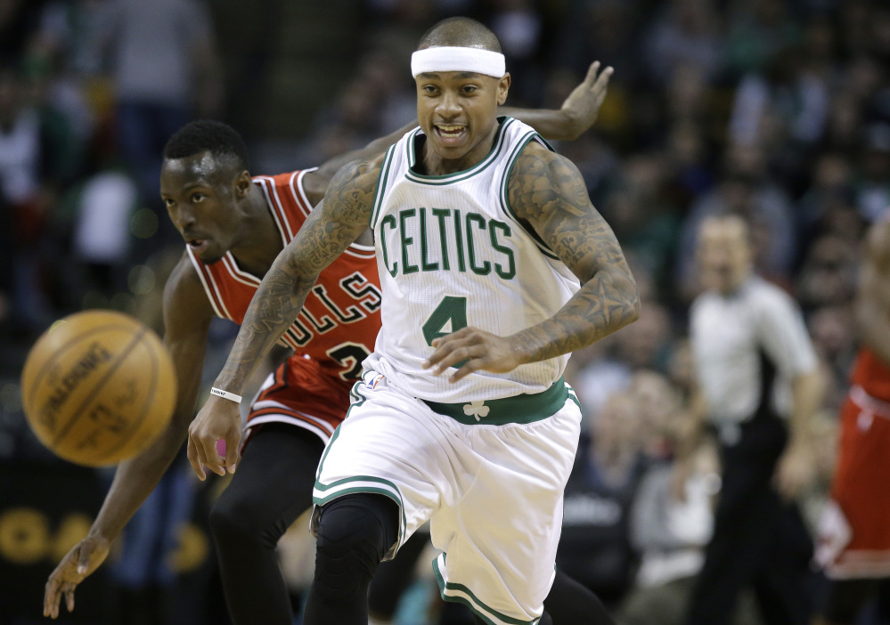 Boston Celtics guard Isaiah Thomas (4) and Chicago Bulls guard Jerian Grant (2) chase after a loose ball in the first quarter Sunday in Boston.