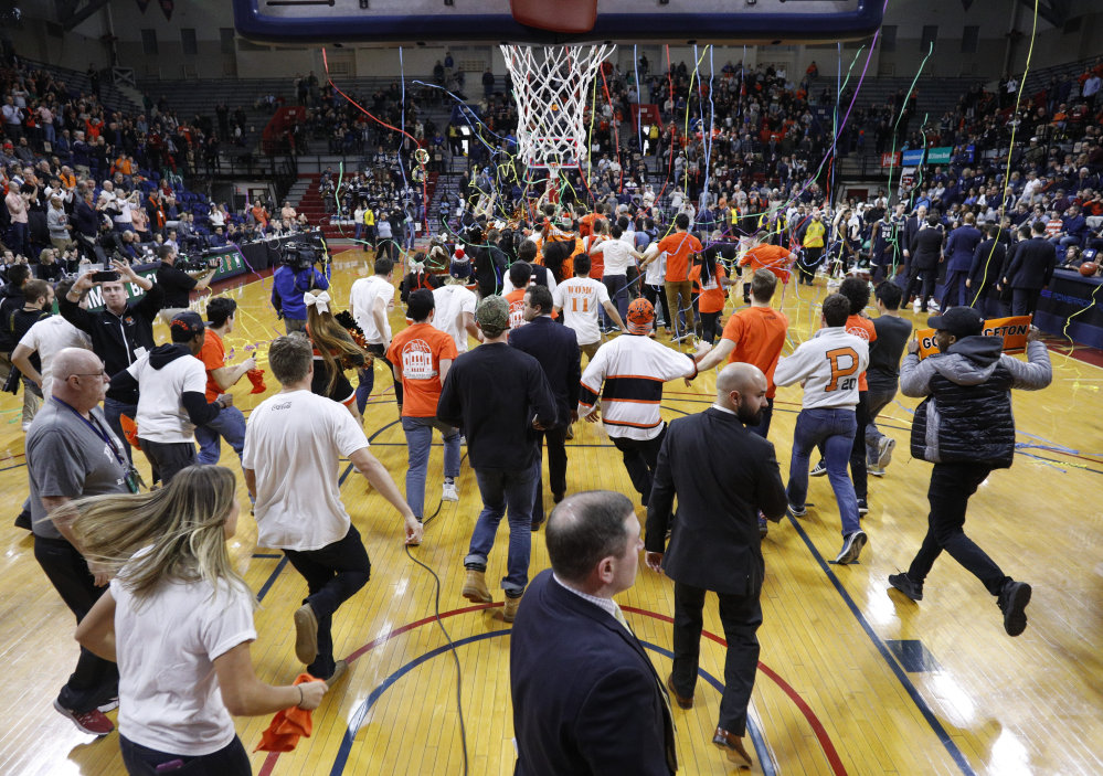 Princeton fans storm the court following the Ivy League championship game against Yale on Sunday.