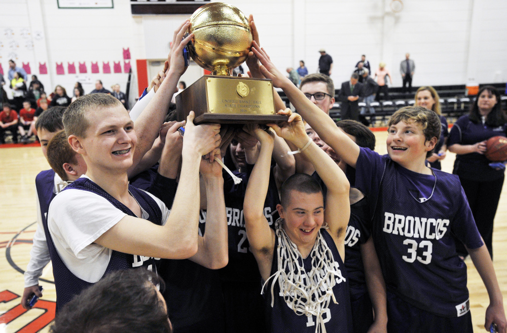 Hampden Academy unified basketball players celebrate with a Gold Ball after winning the state championship last season.