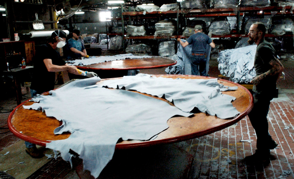 Employees at Tasman Leather Group work at a station on July 20, 2016, at the Hartland mill.
